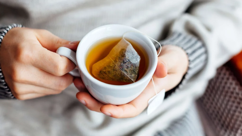 Close up of a woman holding a hot cup of tea